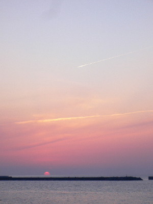 沈む夕日と飛行機雲
